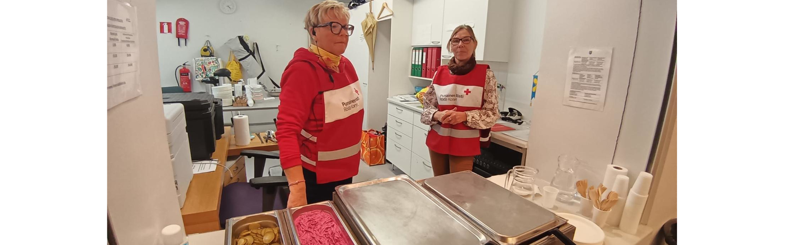 Kaksi SPR:n vapaaehtoista ruokatarjoilussa. 
